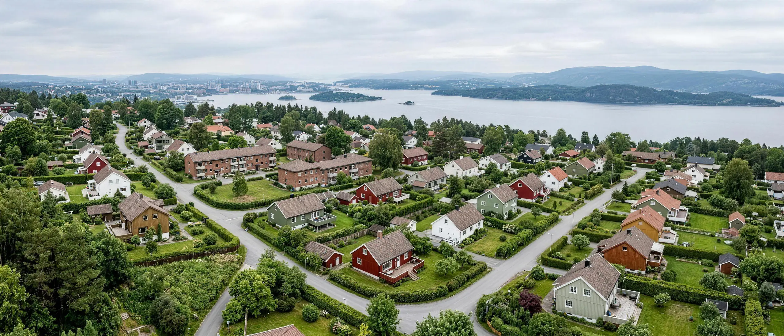 Villaområde i Oslo sett ovenfra i lavt dagslys, hager, tomtegrenser og småhus.